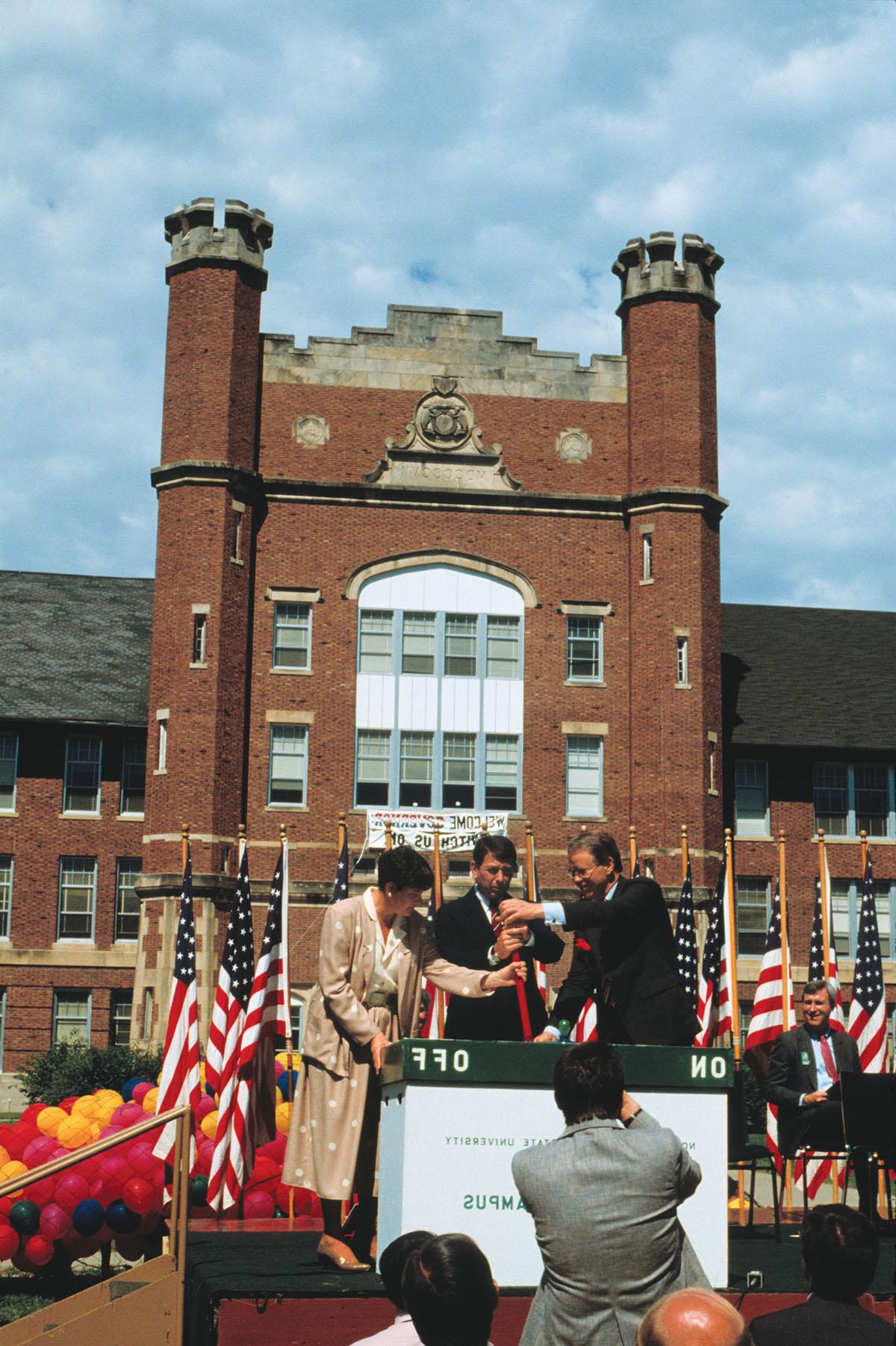 Northwest President Dean 哈伯德 (left) pulls a ceremonial switch, marking the launch of the University’s “Electronic Campus” on Aug. 18, 1987, with Gov. John Ashcroft and Shaila Aery, Missouri’s commissioner for higher education. Northwest was the first public university in the nation to have a campus-wide computing system.